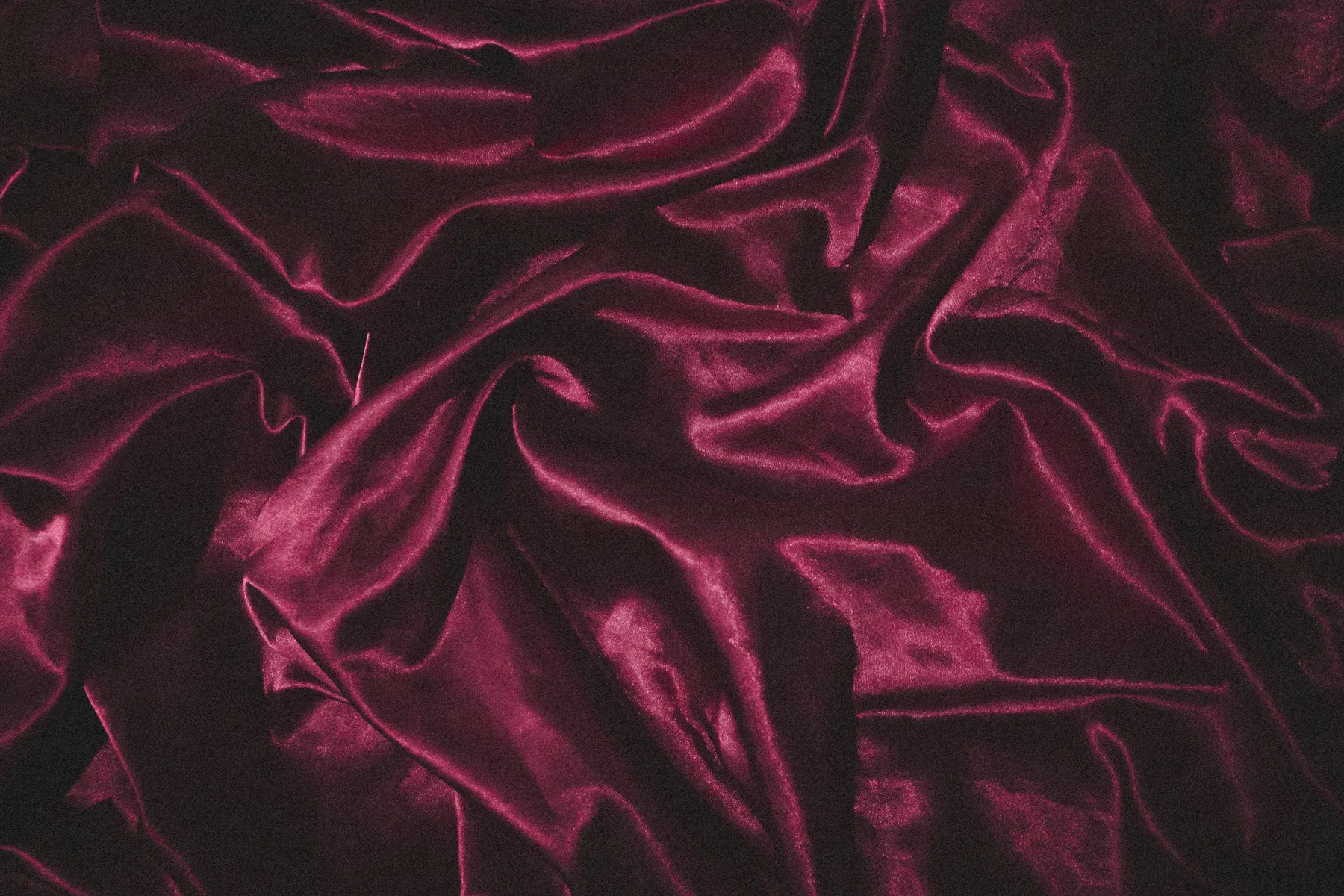 Deep magenta satin in loose folds, catching a low light